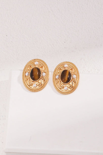 The Royal Tiger's Eye and Pearl Vintage Gold Earrings by Siren Mode feature an ornate circular design, showcasing a central polished stone of Tiger's Eye. Encased by natural pearls and intricate detailing, these vintage earrings are perfectly displayed against a white backdrop.