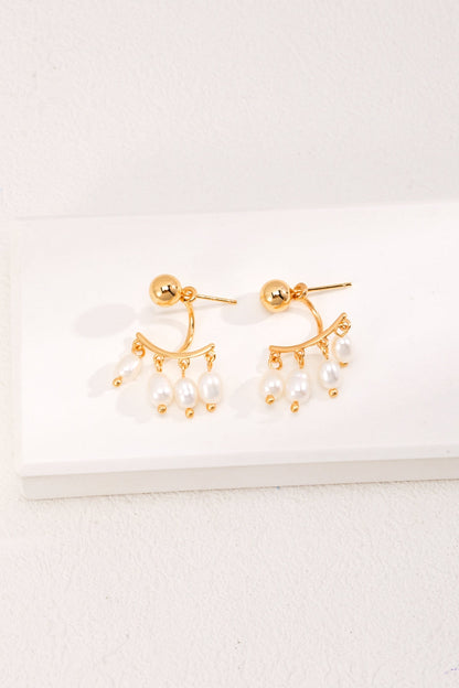 A pair of Siren Mode's Vintage Gold 925 Silver Natural Pearl Drop Earrings featuring small hoop designs adorned with several dangling natural pearl-like beads displayed on a white rectangular surface against a white background.