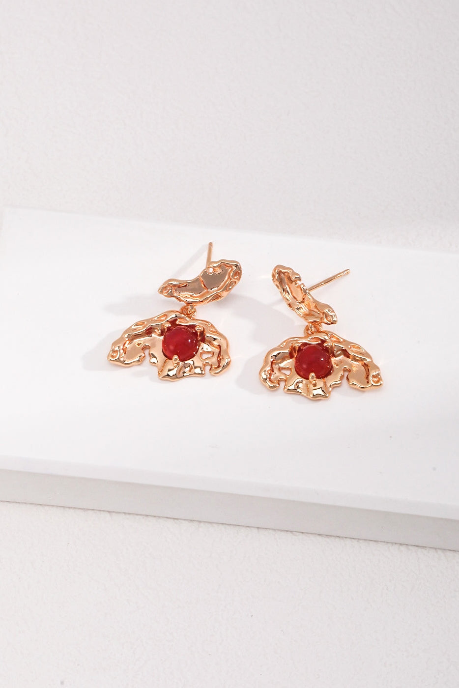 A stunning pair of Vintage Gold 925 Silver Red Agate Drop Earrings by Siren Mode, featuring intricate abstract designs and a red gemstone at the center of each piece, beautifully crafted from 925 silver red agate. The earrings are elegantly displayed on a white surface against a light background.