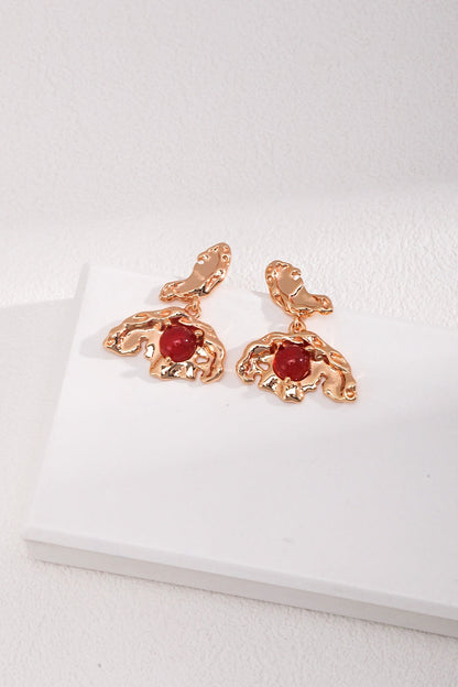 A pair of Siren Mode Vintage Gold 925 Silver Red Agate Drop Earrings with an abstract, wavy design, each featuring a central red agate stone. The drop earrings are displayed on a white surface, with a minimalistic and clean background.